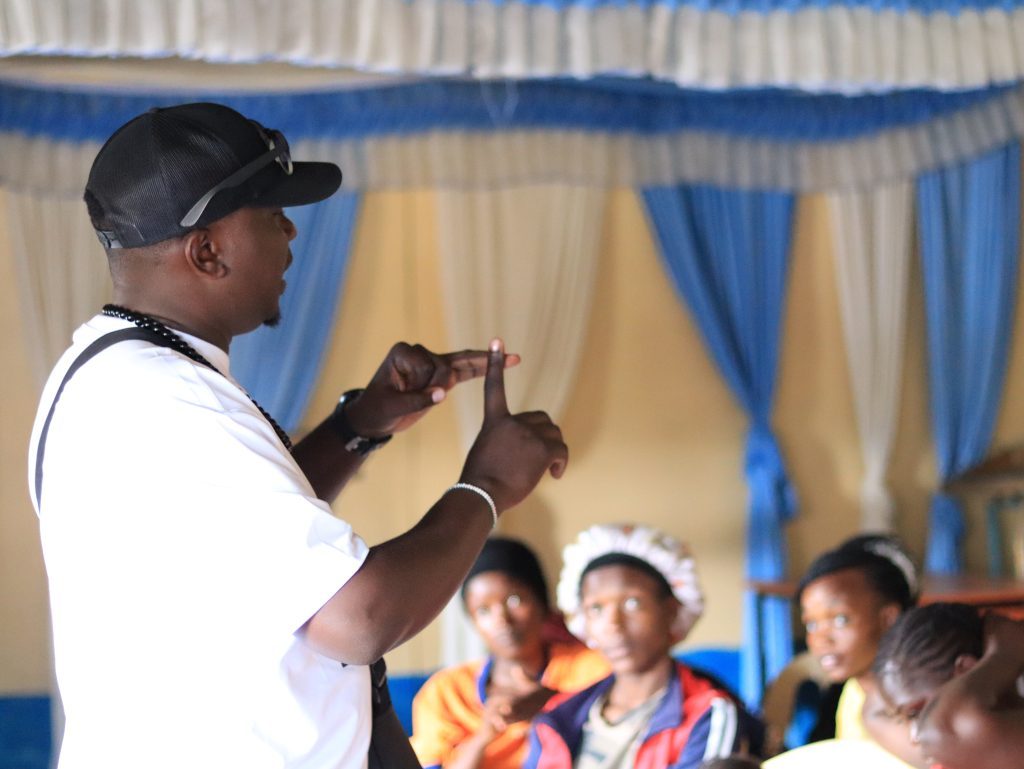 Titus speaking with his hands as a group listens
